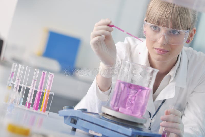 Female researcher holding up a test tube in lab