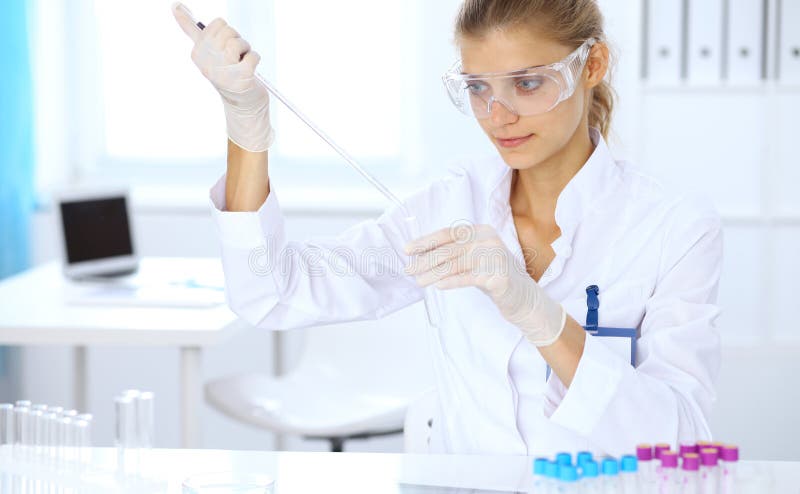 Female scientific researcher or blood test assistant at work in laboratory. Science, medicine and pharmacy concept