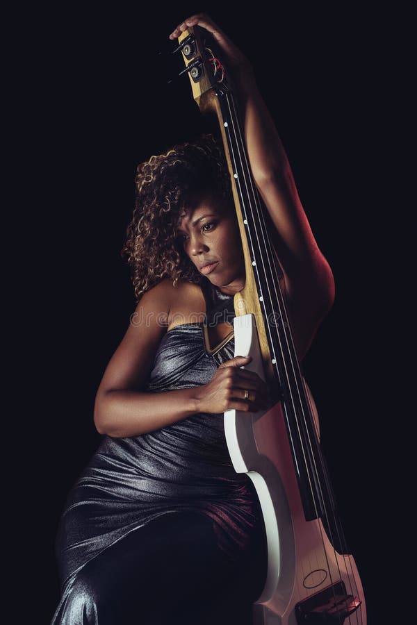Sensual musician. African girl playing double bass. stock photo Sensual musician. African girl playing double bass. stock photo