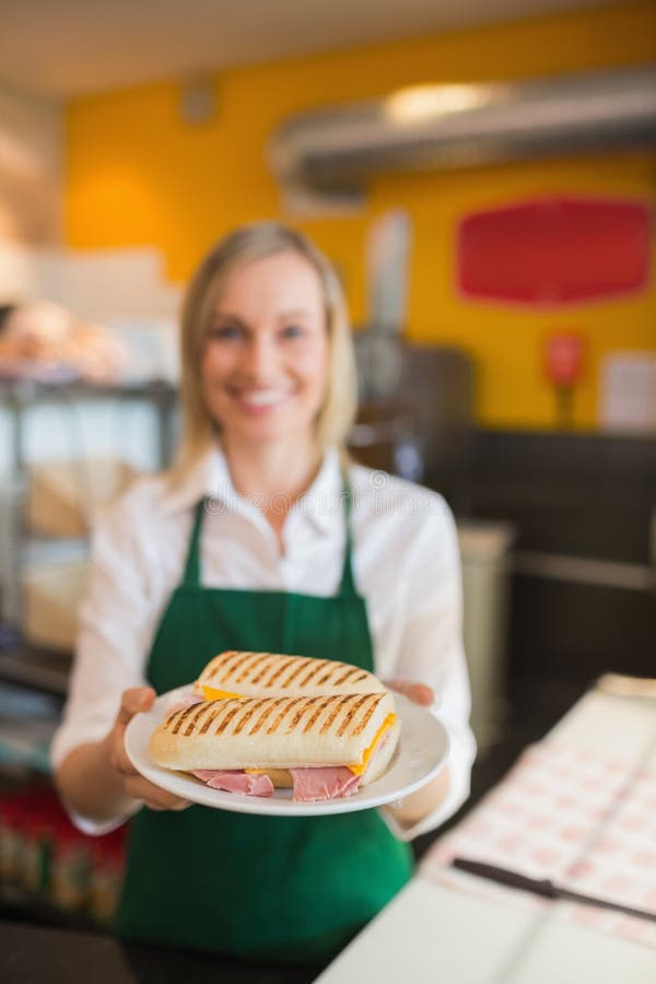 Female shop owner serving sandwich royalty free stock photos Female shop owner serving sandwich royalty free stock photos