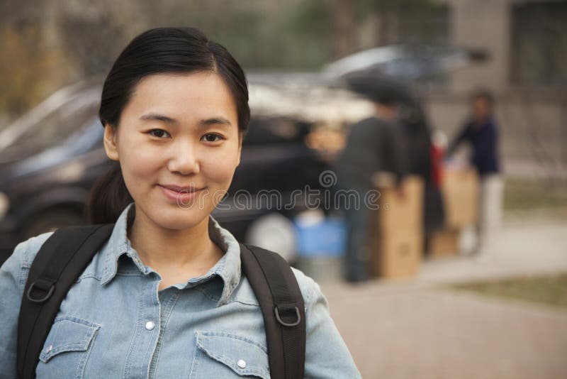 Female smiling student portrait in front of dormitory at college stock photo