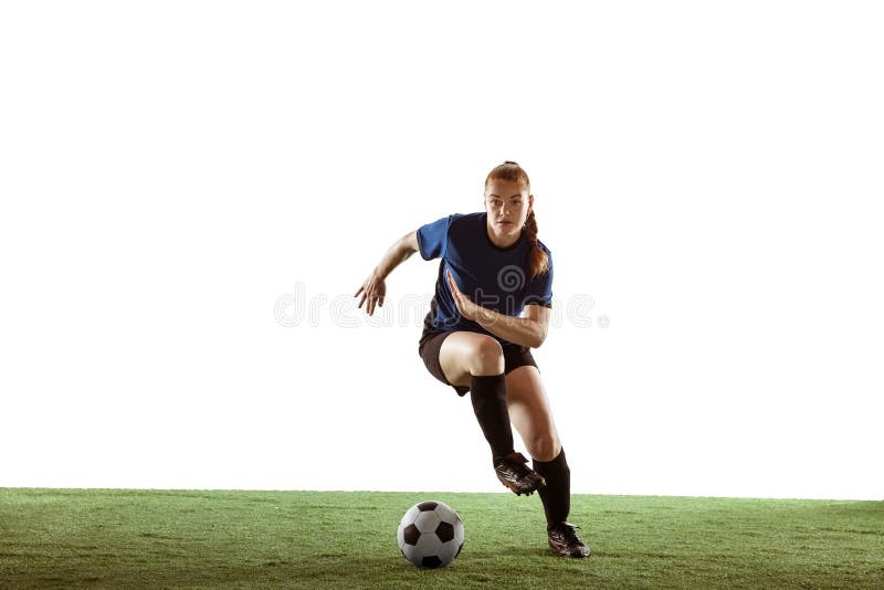 Young female soccer or football player with long hair in sportwear kicking ball for the goal, training on white studio background. Concept of healthy lifestyle, professional sport, motion, movement. Young female soccer or football player with long hair in sportwear kicking ball for the goal, training on white studio background. Concept of healthy lifestyle, professional sport, motion, movement.