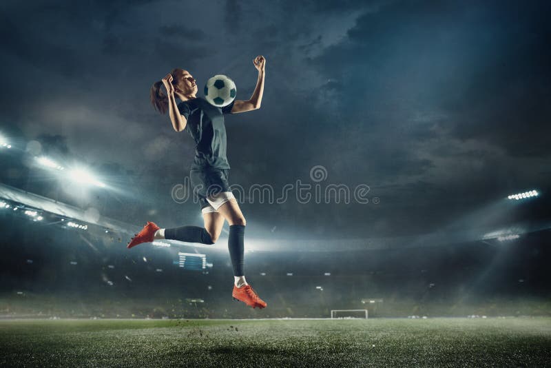 Young female soccer or football player with long hair in sportwear and boots kicking ball for the goal in jump at the stadium. Concept of healthy lifestyle, professional sport, hobby, motion, movement. Young female soccer or football player with long hair in sportwear and boots kicking ball for the goal in jump at the stadium. Concept of healthy lifestyle, professional sport, hobby, motion, movement.