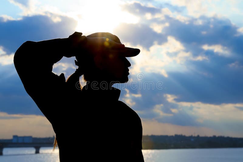Female soldier in uniform saluting outdoors. Military