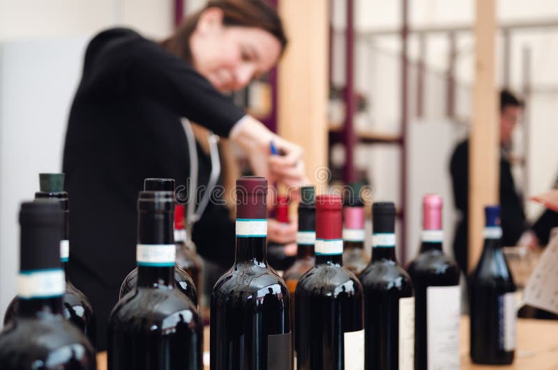 Female sommelier uncorking a bottle of red dolcetto wine in piedmont, italy stock photography Female sommelier uncorking a bottle of red dolcetto wine in piedmont, italy stock photography