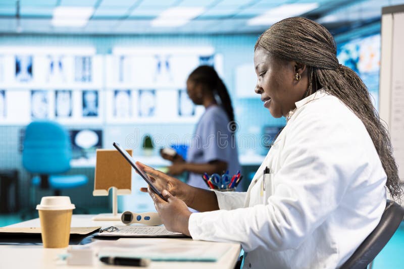 Female specialist using clinical scans and records to advise a patient stock photography