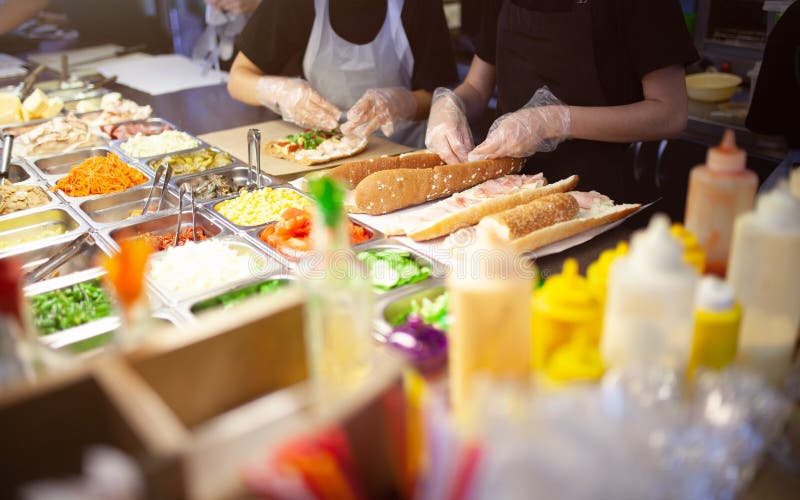 Female street vendor hands making sandwich outdoors. cuisine snacks, cooking fast food for commercial kitchen. stock image Female street vendor hands making sandwich outdoors. cuisine snacks, cooking fast food for commercial kitchen. stock image