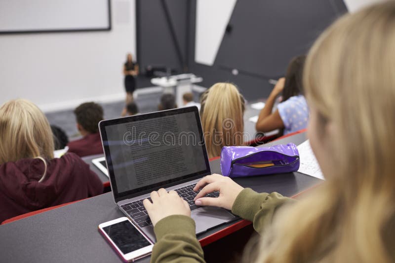 Female student using laptop at a university lecture royalty free stock photography