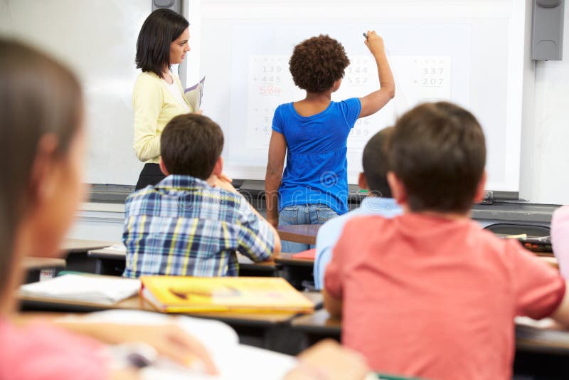 Female Student Writing Answer On Whiteboard stock images