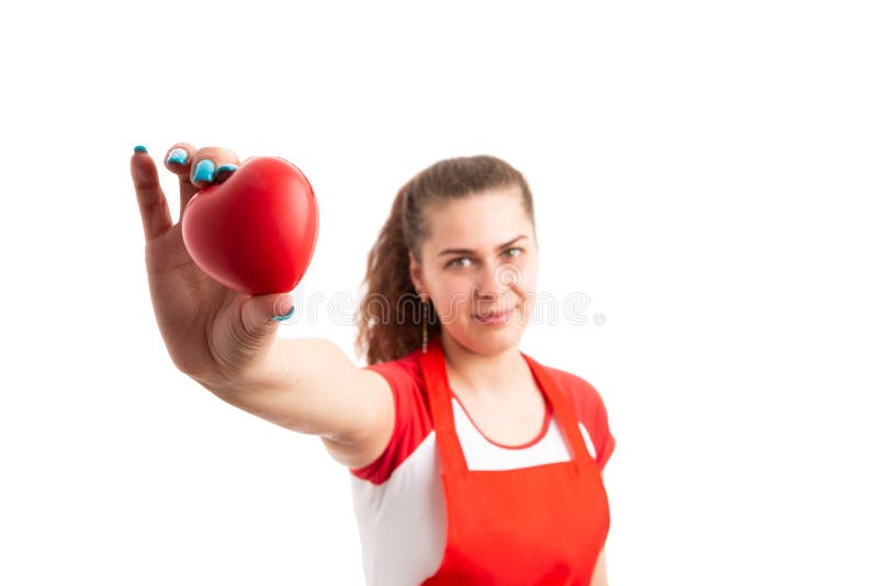 Young female supermarket or hypermarket employee holding red toy heart as love for work job concept isolated on white background