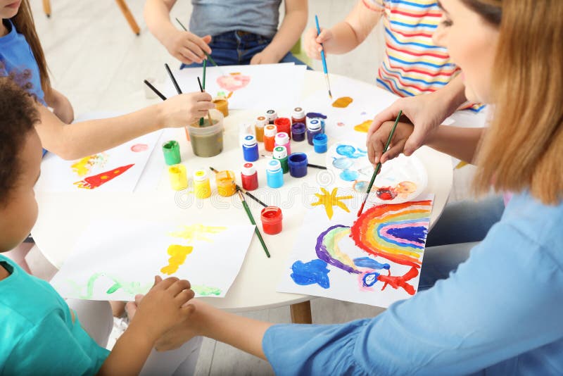 Female teacher with children at painting lesson stock photo Female teacher with children at painting lesson stock photo