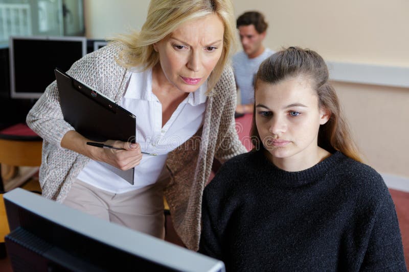 Female teacher with student with laptop royalty free stock photography