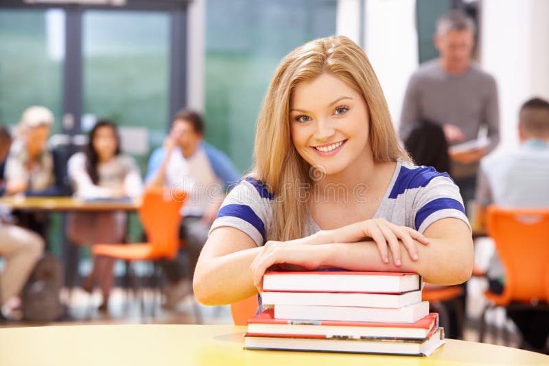 Female Teenage Student In Classroom With Books royalty free stock image