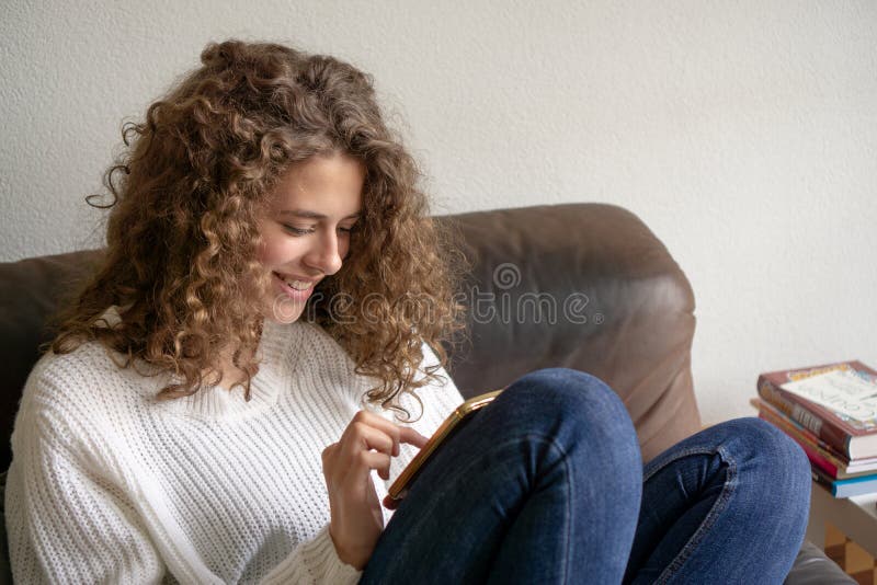 Female teenager sitting in a chair being busy with her digital p royalty free stock image Female teenager sitting in a chair being busy with her digital p royalty free stock image