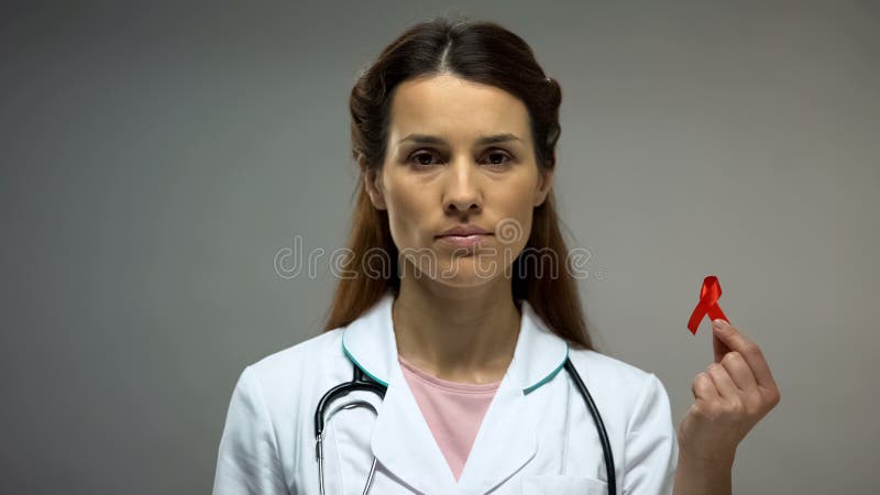 Female therapist showing red ribbon before camera, safe sex, AIDS prevention royalty free stock photo Female therapist showing red ribbon before camera, safe sex, AIDS prevention royalty free stock photo