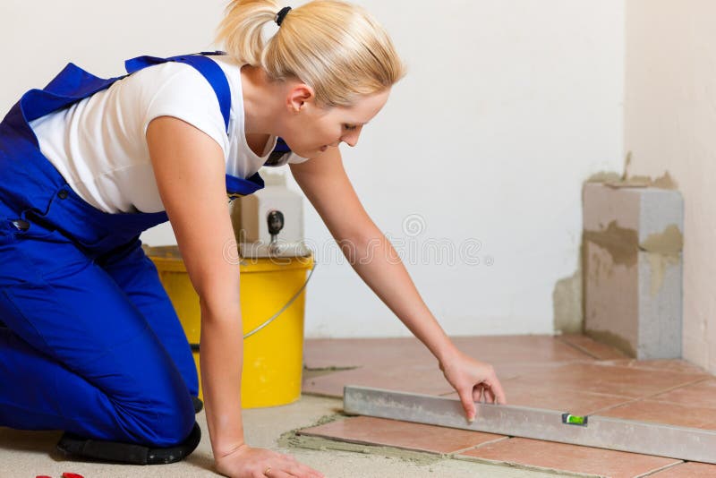 Female tiler tiling tiles on the floor stock photography Female tiler tiling tiles on the floor stock photography