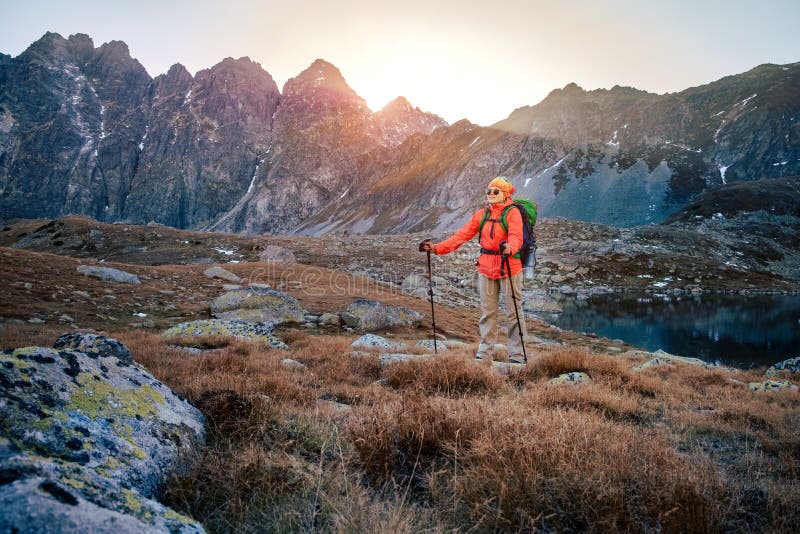 Turistická turistika ve Vysokých Tatrách při zlatém západu slunce, Slovensko