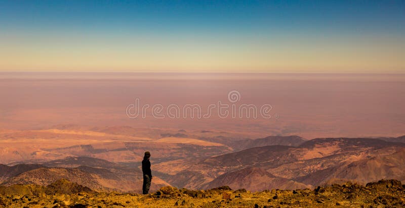 Female trekker enjoys the view from the summit of Jbel Toubkal, Atlas Mountains, Morocco. stock photography Female trekker enjoys the view from the summit of Jbel Toubkal, Atlas Mountains, Morocco. stock photography
