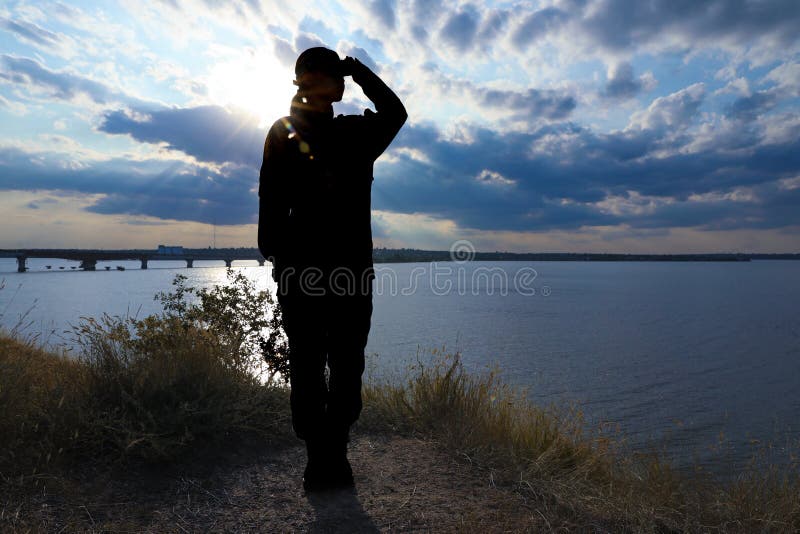 Female  in uniform saluting outdoors. Military service