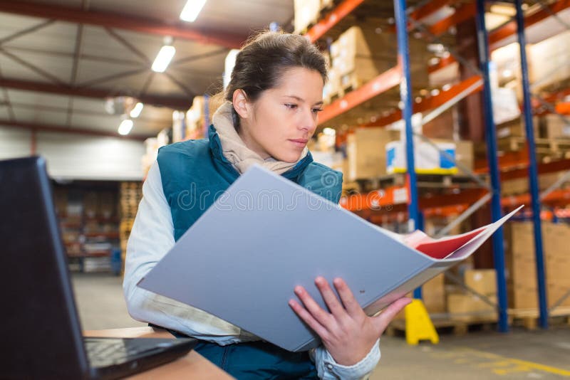 Female warehouse manager with file folder in warehouse