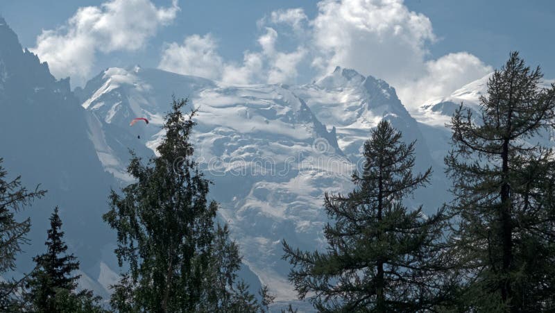 Females hikers enjoy the views of para gliders and the mountains over the valley of Chamonix, France and toward Mont Blanc in the french alps. Females hikers enjoy the views of para gliders and the mountains over the valley of Chamonix, France and toward Mont Blanc in the french alps.