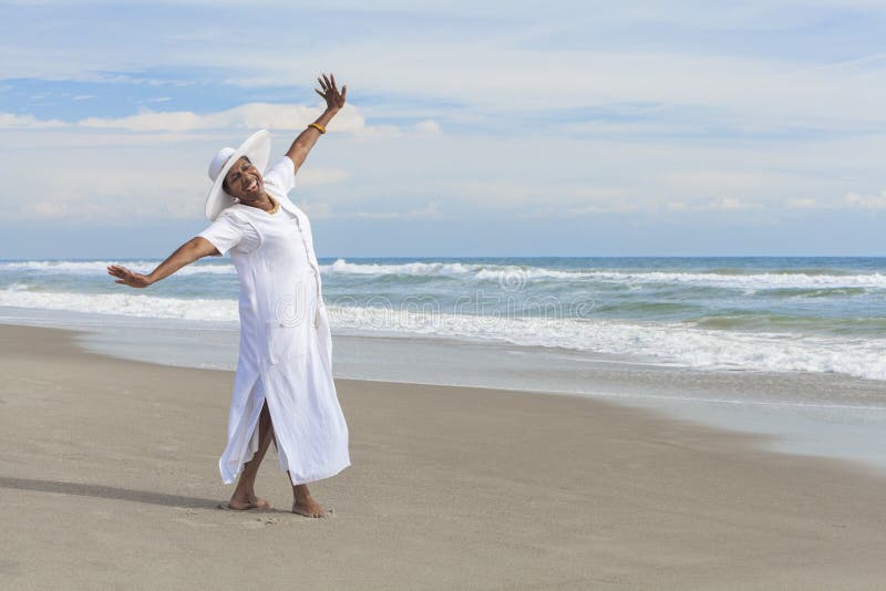 Femeie afro-americană fericită dansând pe plajă stock photos