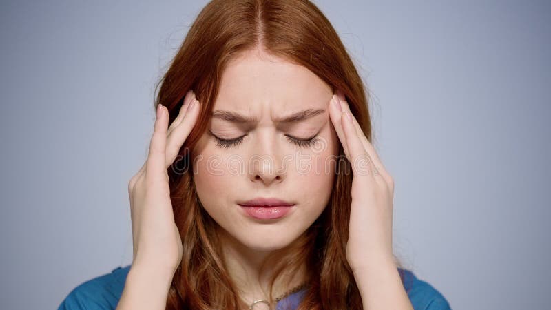 Femeie apatică cu dureri de cap în interior. fată tristă suferind de durere în studio stock footage