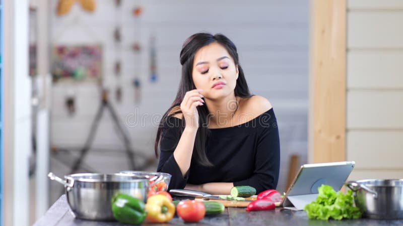 Femeie asiatică tânără și elegantă care gătește mâncare proaspătă, cu dureri de cap medii stock video footage