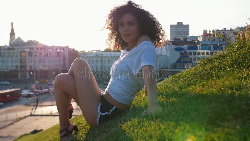 Femeie atrăgătoare și slabă care zace pe iarbă și care face dansuri pe dezbrăcate o mângâie pe spate și se simte stock footage