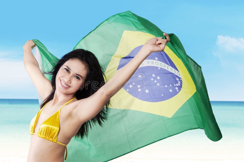 Femeie care deține pavilionul brazilian pe litoral royalty free stock photos