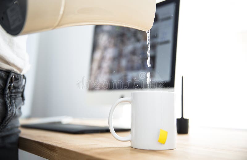 Femeie cu ceainic turnând apă într-o cană royalty free stock image