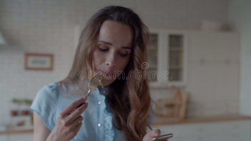 Femeie de afaceri închisă care ia prânzul în bucătăria modernă. fată mănâncă salată. stock video footage