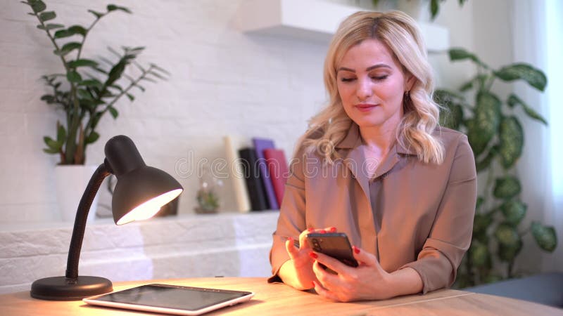 Femeie de afaceri închisă tastează mesaje pe telefon mobil la biroul de acasă. tânără care vorbește pe chat stock footage