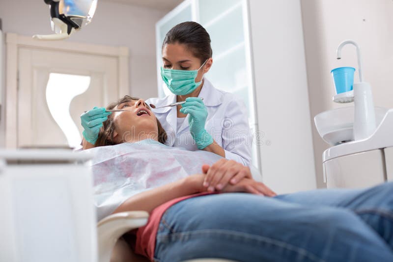 Femeie profesionistă care se ocupă cu verificarea sănătății dentare a pacienților stock images