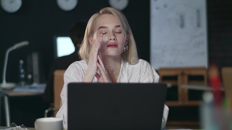 Femeie suprasolicitată care are dureri de cap în biroul de noapte. femeie stresată care lucrează târziu stock video