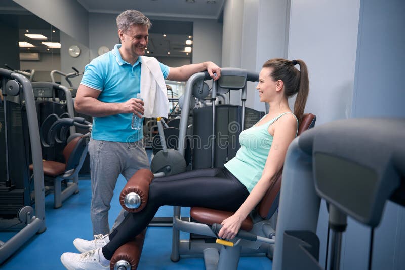 Femelle faisant l'exercice de corps inférieur en présence d'entraînement compagnon photographie stock