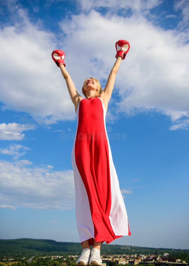 Femininity and strength balance. Woman red dress and boxing gloves enjoy victory. She fighter female rights. Lady