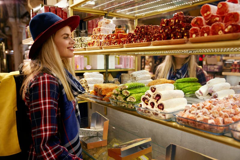 Femme achetant les bonbons turcs au marché oriental de nourriture photographie stock libre de droits Femme achetant les bonbons turcs au marché oriental de nourriture photographie stock libre de droits