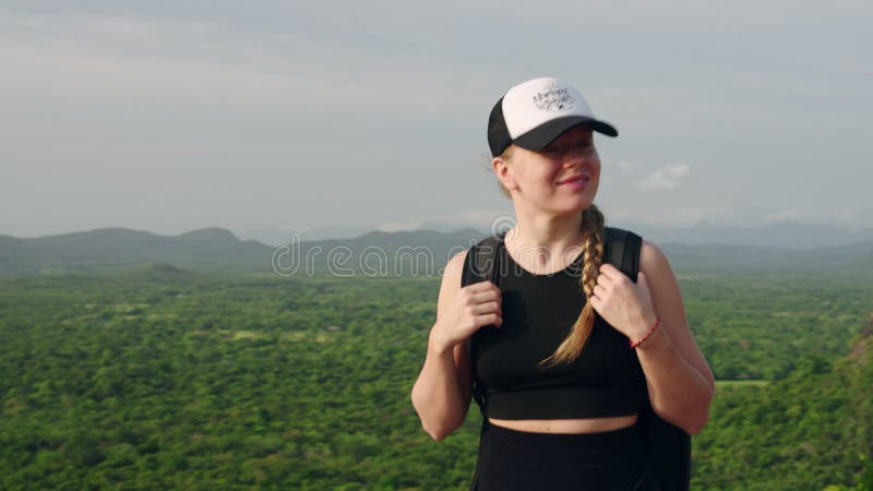 Femme active trek colline contre le rocher de sigiriya fond. randonnée avec sac à dos atteint sommet bénéficie d'une vue panoramiq