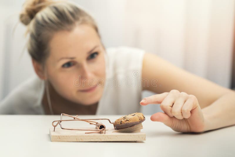Femme affamée essayant de voler le biscuit du piège de souris photographie stock Femme affamée essayant de voler le biscuit du piège de souris photographie stock