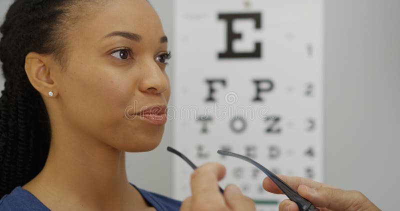 Femme africaine essayant sur ses nouveaux verres photographie stock libre de droits Femme africaine essayant sur ses nouveaux verres photographie stock libre de droits