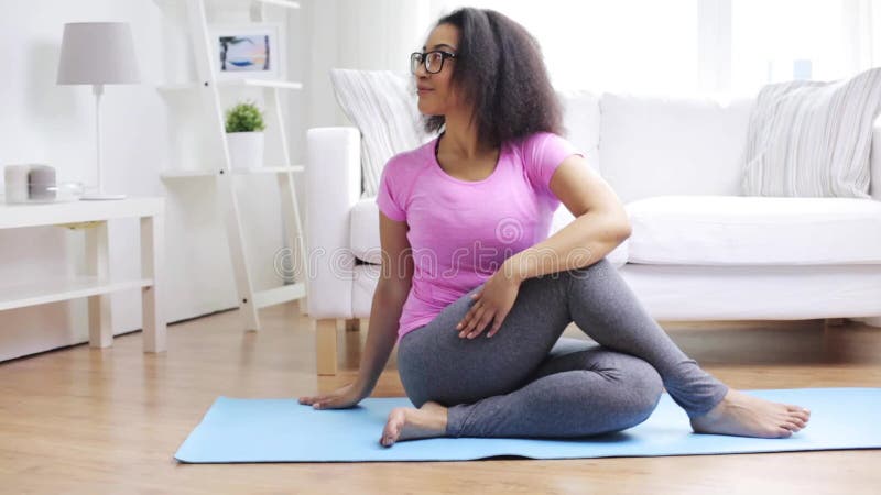 Femme africaine heureuse s'exerçant sur le tapis à la maison