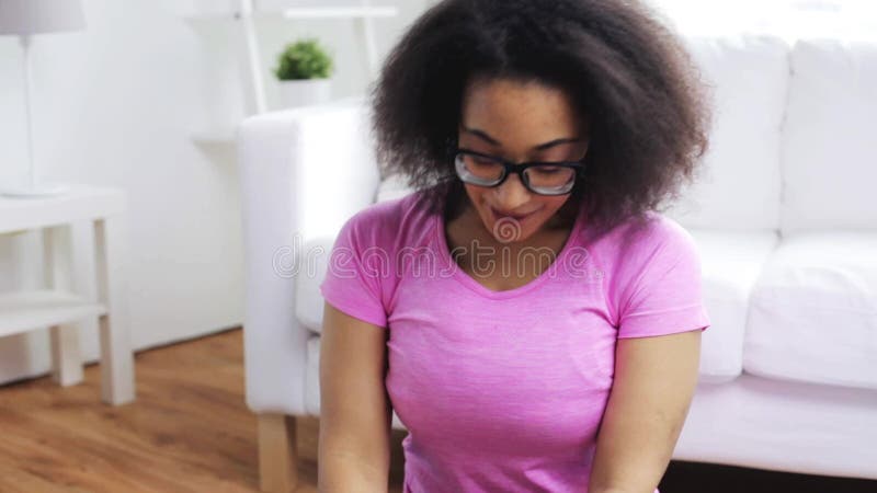 Femme africaine heureuse s'exerçant sur le tapis à la maison