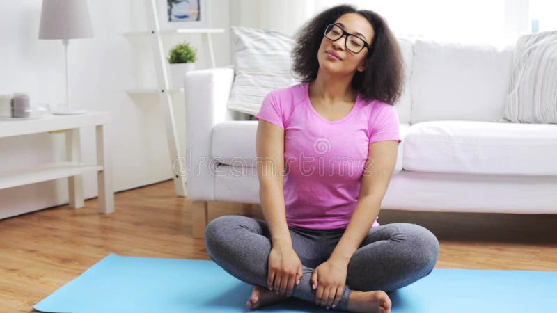 Femme africaine heureuse s'exerçant sur le tapis à la maison