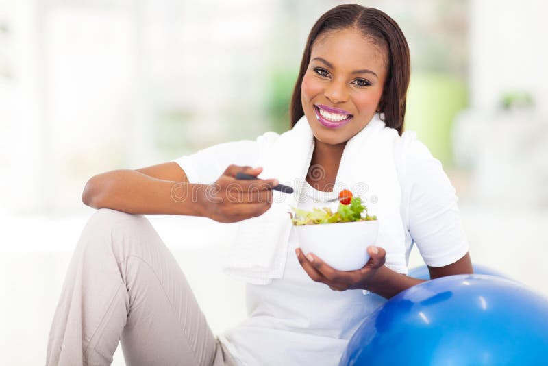 Femme africaine mangeant le légume image stock
