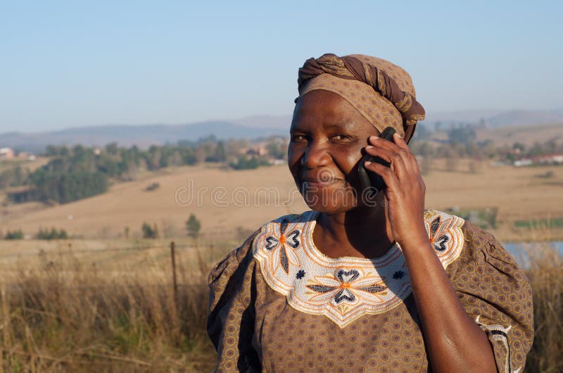 Femme africaine traditionnelle de zoulou parlant du téléphone portable photographie stock Femme africaine traditionnelle de zoulou parlant du téléphone portable photographie stock