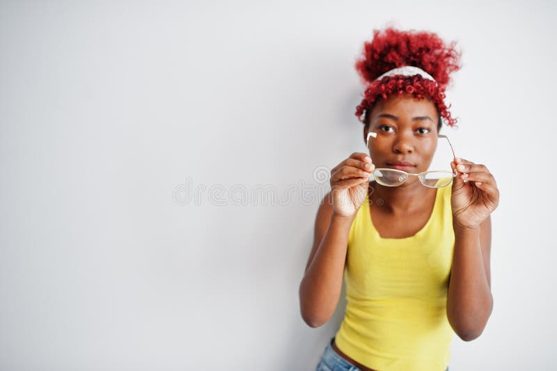 Femme afro-américaine en singlet jaune et lunettes contre mur blanc photo libre de droits