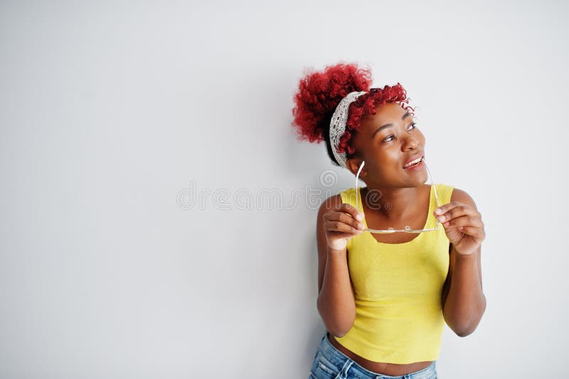 Femme afro-américaine en singlet jaune et lunettes contre mur blanc photos libres de droits