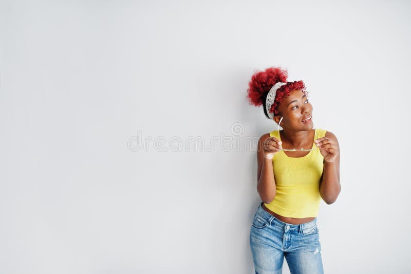 Femme afro-américaine en singlet jaune et lunettes contre mur blanc images stock
