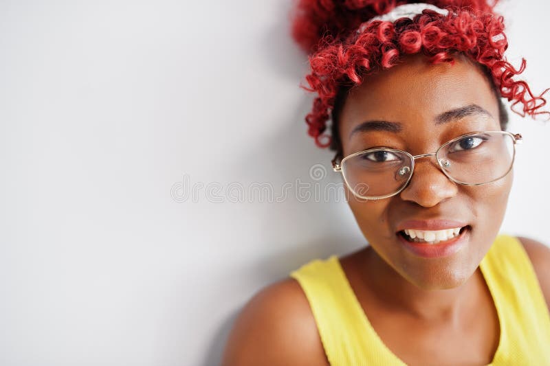 Femme afro-américaine en singlet jaune et lunettes contre mur blanc photo libre de droits